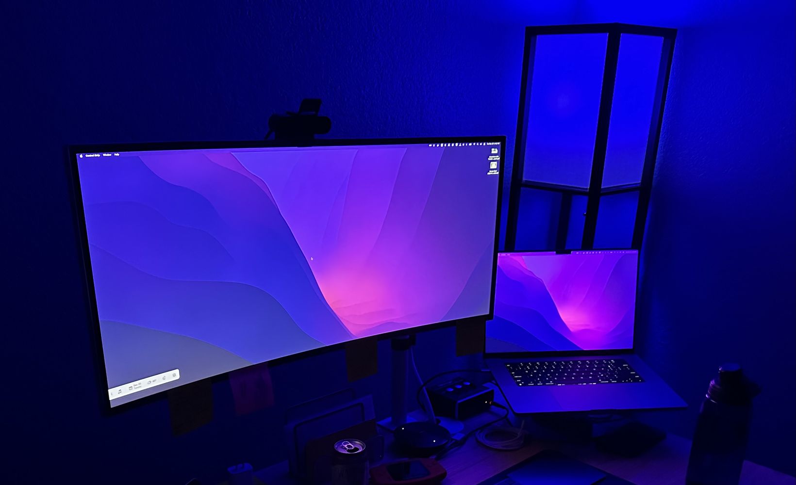 Widescreen monitor on a desk with dark blue lighting in the background